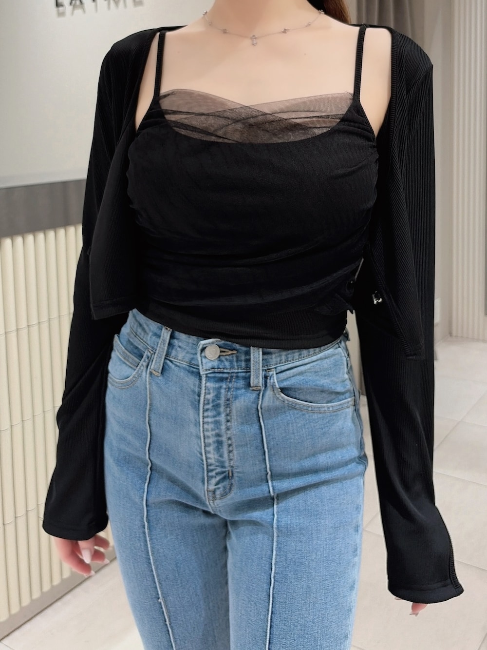 ブラック系のTシャツ/カットソー、ブルー系のデニムパンツ、ブラック系のブーツを着用したレディースの春コーディネートの5枚目の写真