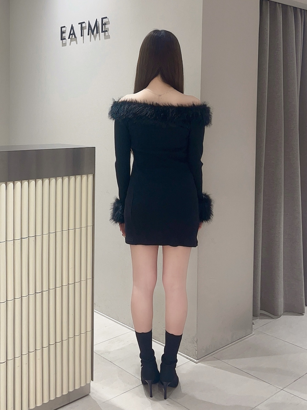 ブラック系のワンピース、ブラック系のブーツを着用したレディースの秋コーディネートの4枚目の写真