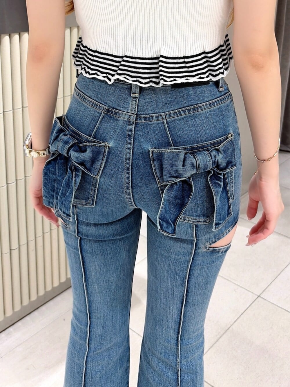 ホワイト系のキャミソール、ブルー系のデニムパンツ、その他のパンプスを着用したレディースの夏コーディネートの5枚目の写真