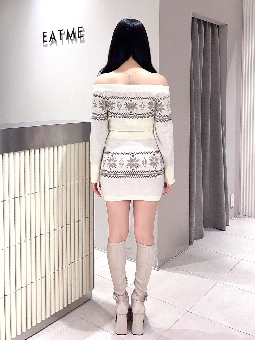 ホワイト系のニット/セーター、ホワイト系のスカート、ホワイト系のブーツを着用したレディースの秋コーディネートの3枚目の写真