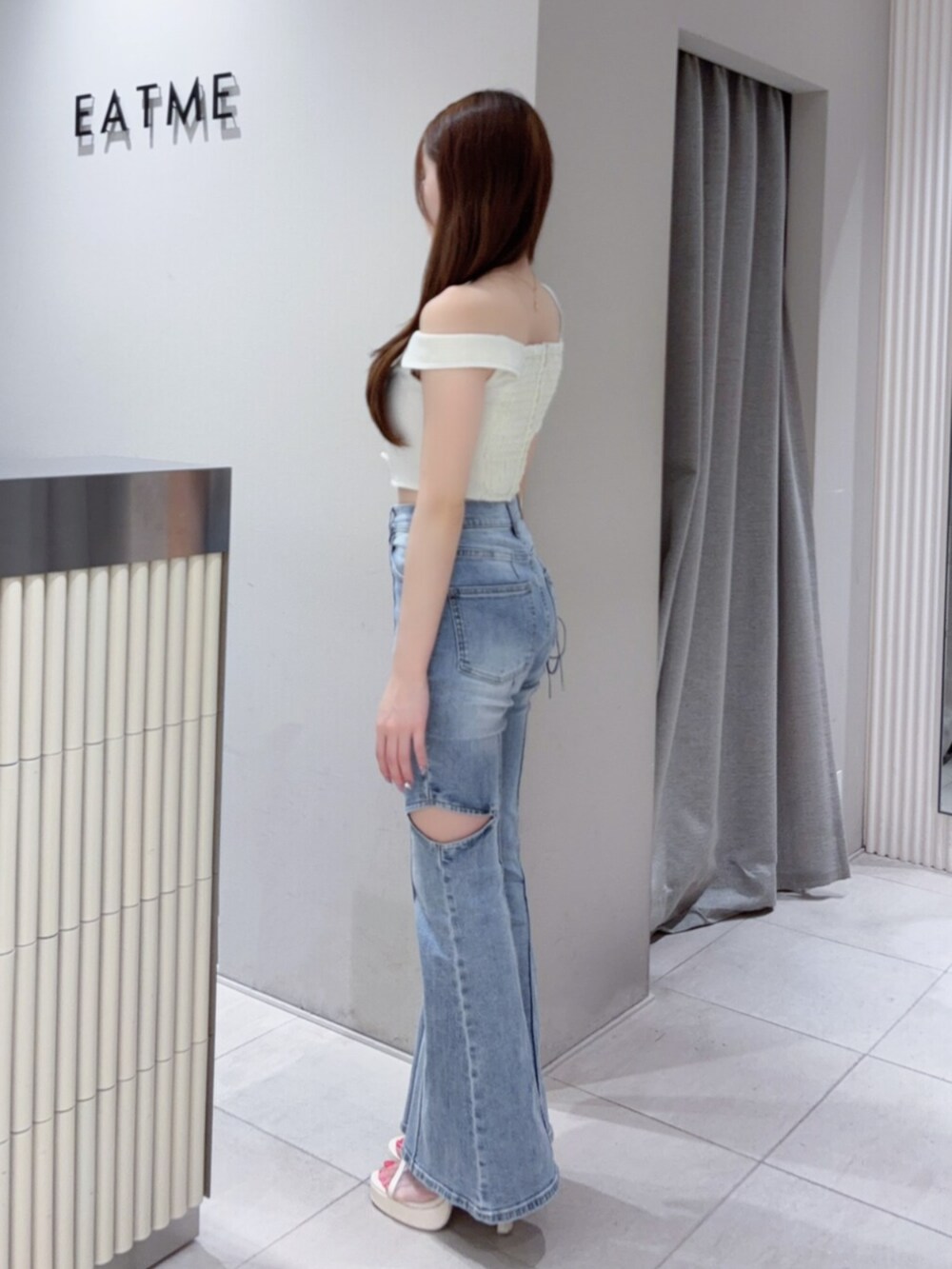 ホワイト系のサンダル、ホワイト系のショルダーバッグ、ブルー系のデニムパンツを着用したレディースの夏コーディネートの3枚目の写真