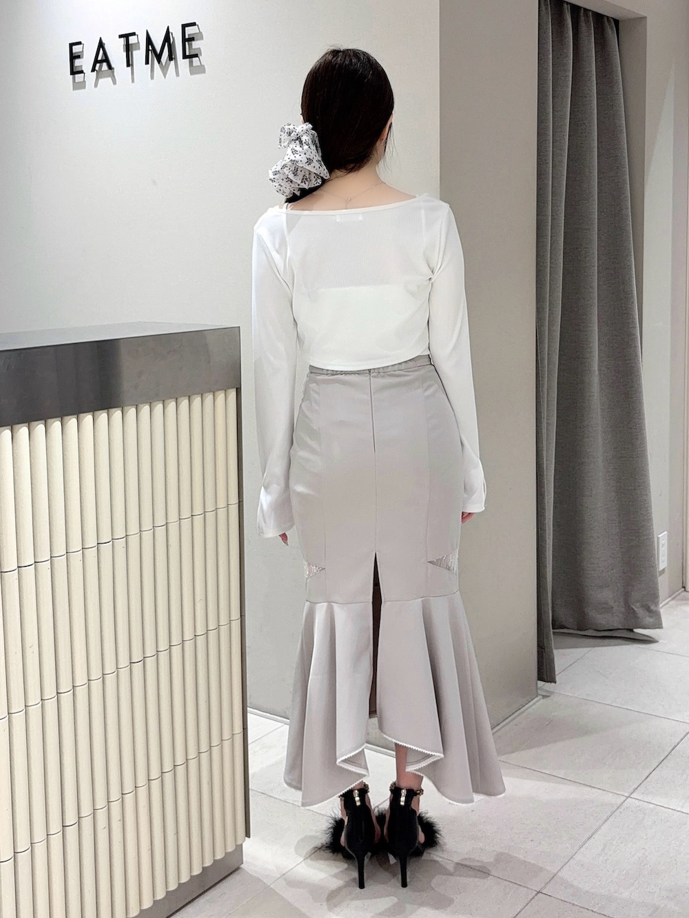 ホワイト系のTシャツ/カットソー、グレー系のスカート、ブラック系のサンダルを着用したレディースの春コーディネートの3枚目の写真