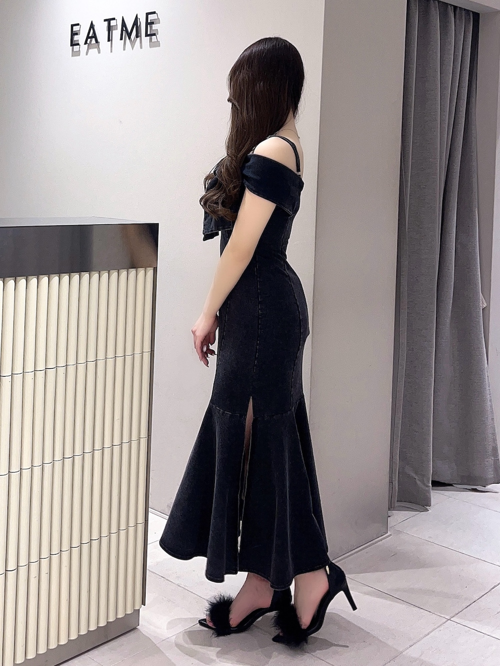 ブラック系のワンピース、ブラック系のサンダルを着用したレディースの春コーディネートの3枚目の写真