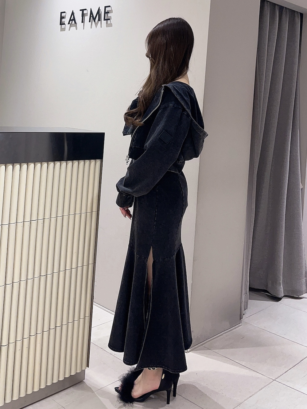 ブラック系のパーカー、ブラック系のワンピース、ブラック系のサンダルを着用したレディースの春コーディネートの2枚目の写真