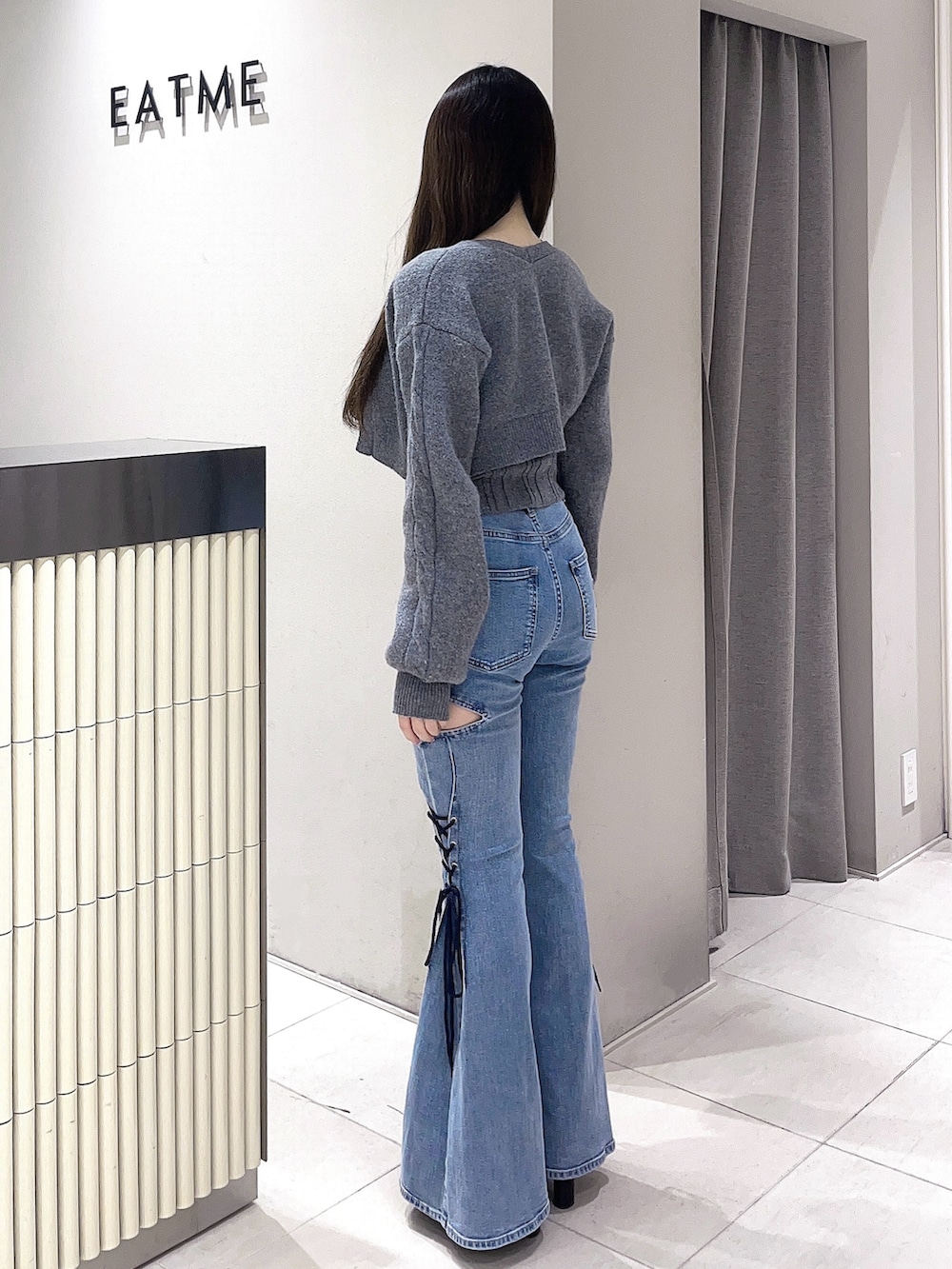 グレー系のニット/セーター、ブルー系のデニムパンツ、ブラック系のブーツを着用したレディースの冬コーディネートの3枚目の写真