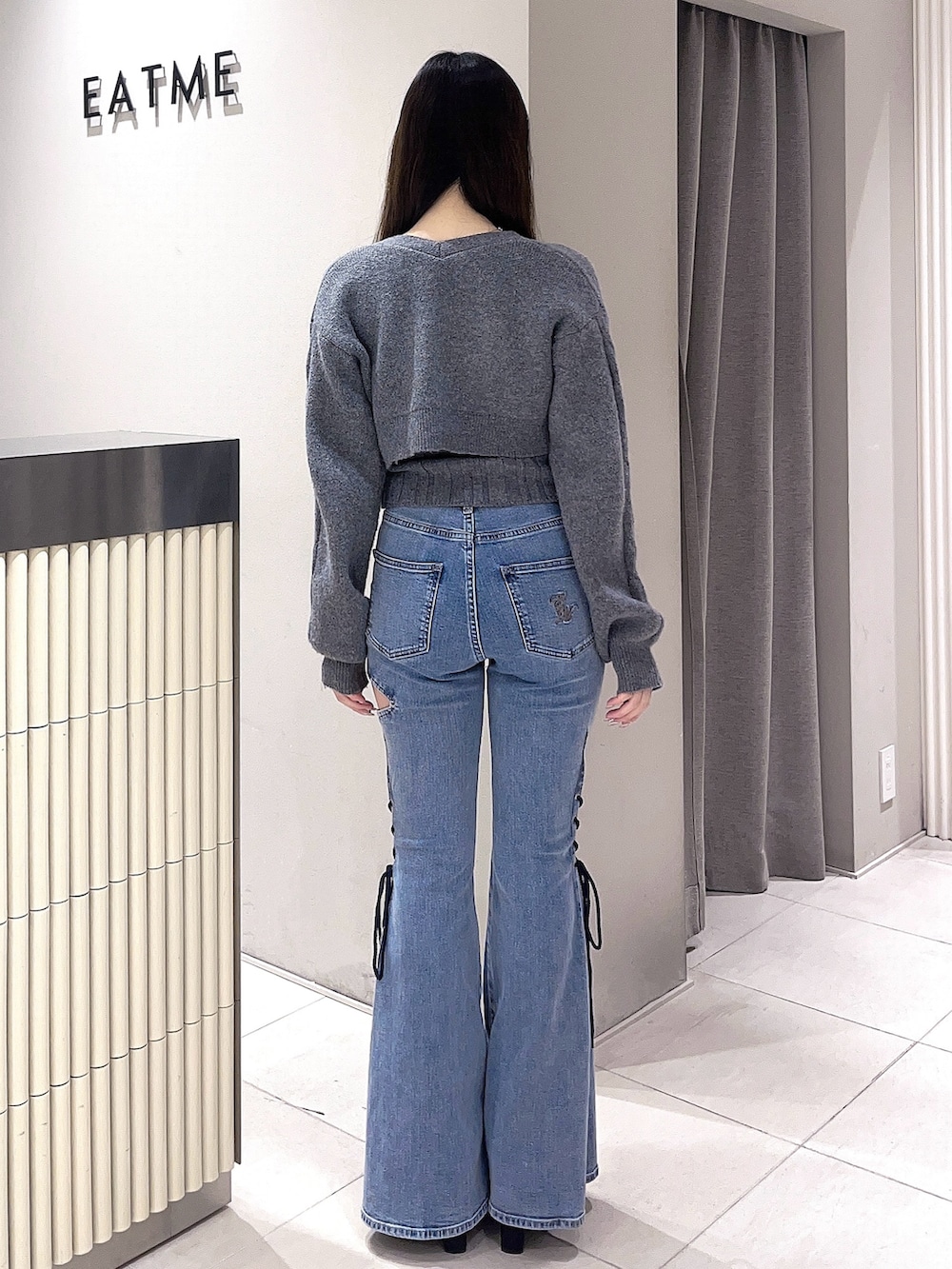 グレー系のニット/セーター、ブルー系のデニムパンツ、ブラック系のブーツを着用したレディースの冬コーディネートの4枚目の写真