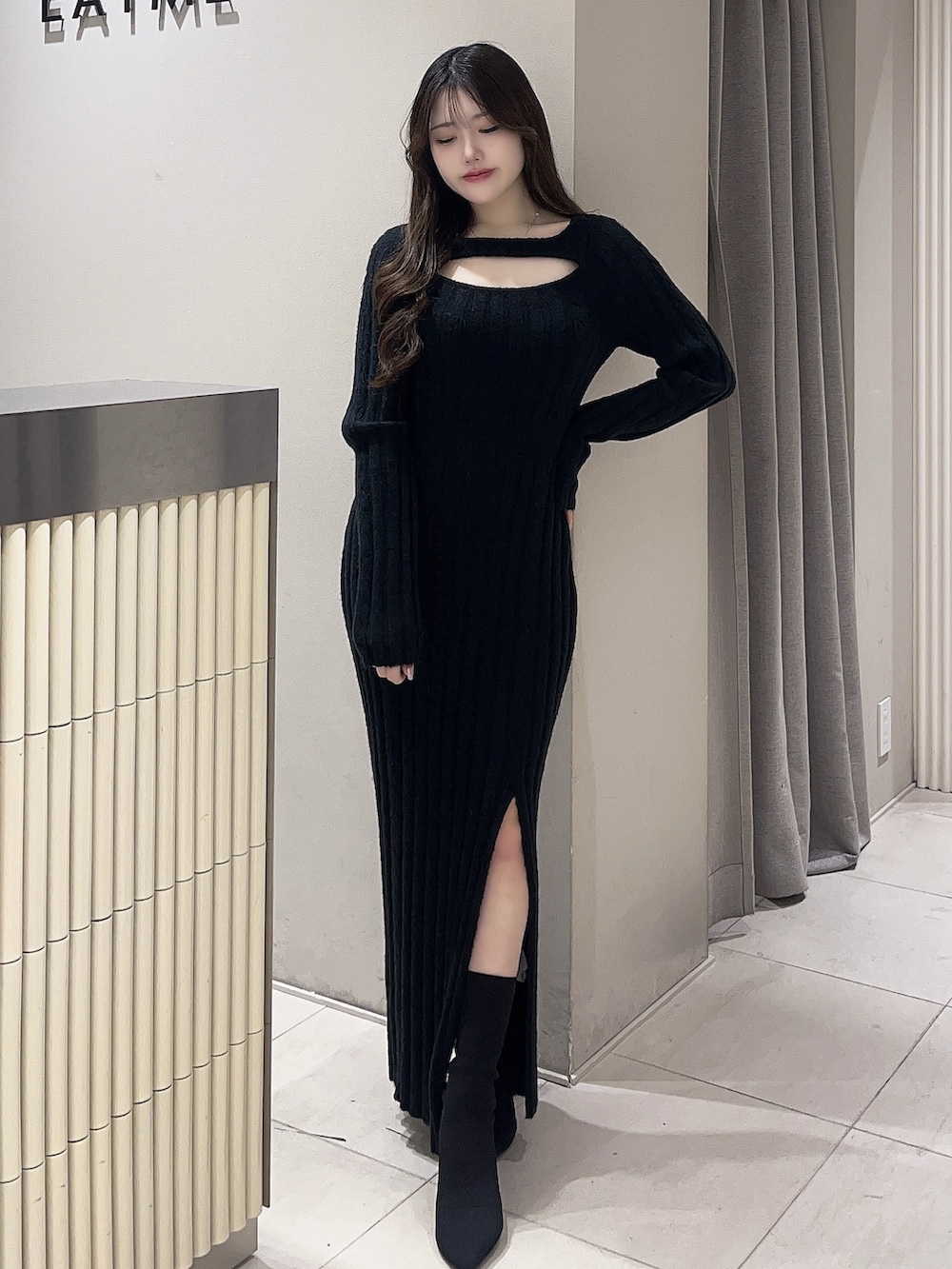 ブラック系のワンピース、ブラック系のブーツを着用したレディースの冬コーディネートの2枚目の写真