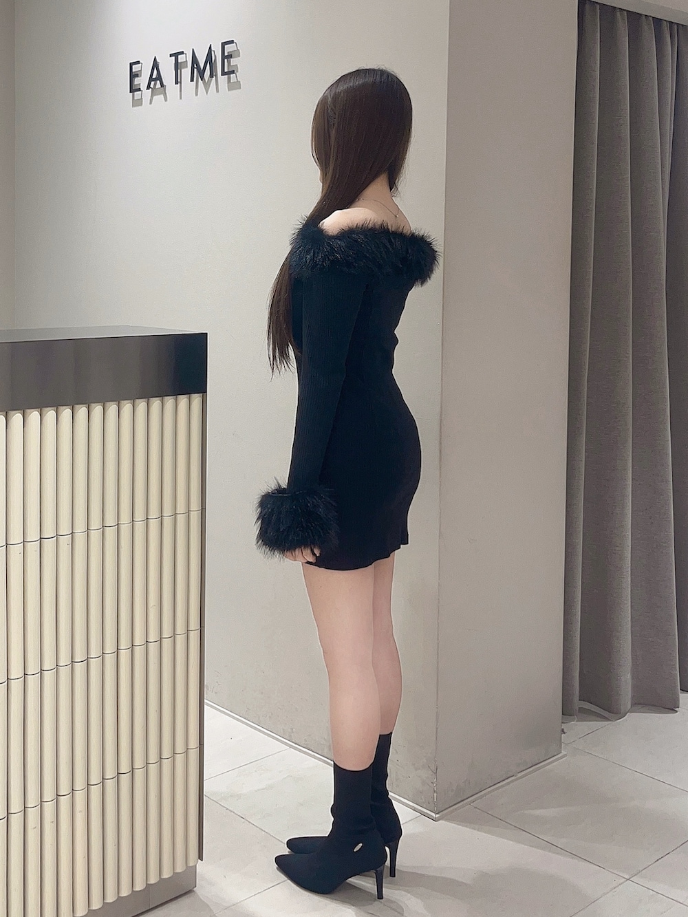 ブラック系のワンピース、ブラック系のブーツを着用したレディースの秋コーディネートの3枚目の写真