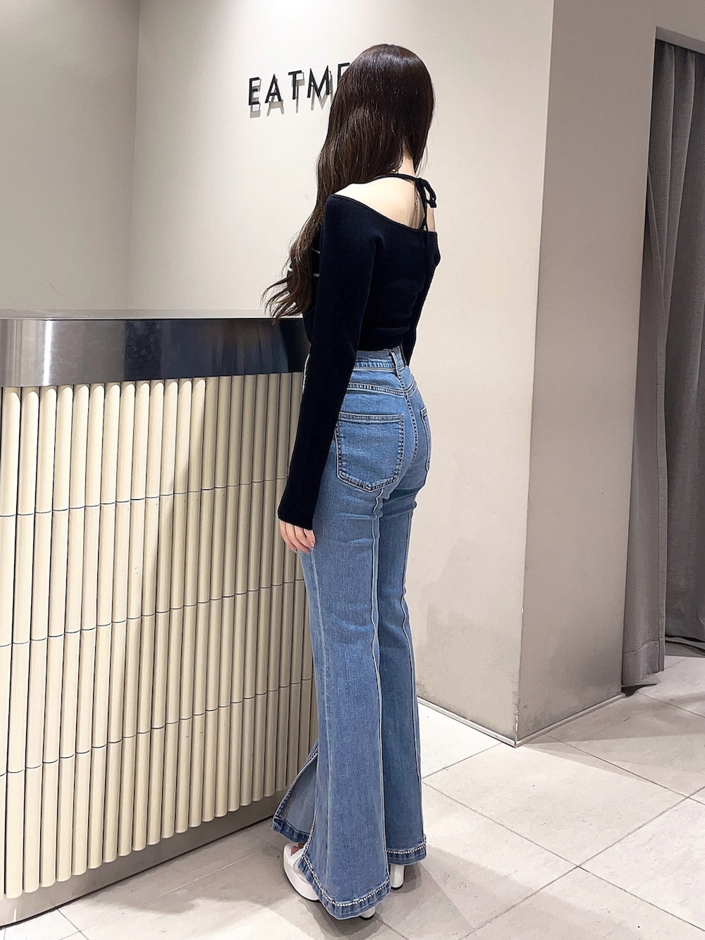 ホワイト系のブーツ、ブルー系のデニムパンツ、ブラック系のニット/セーターを着用したレディースの春コーディネートの3枚目の写真