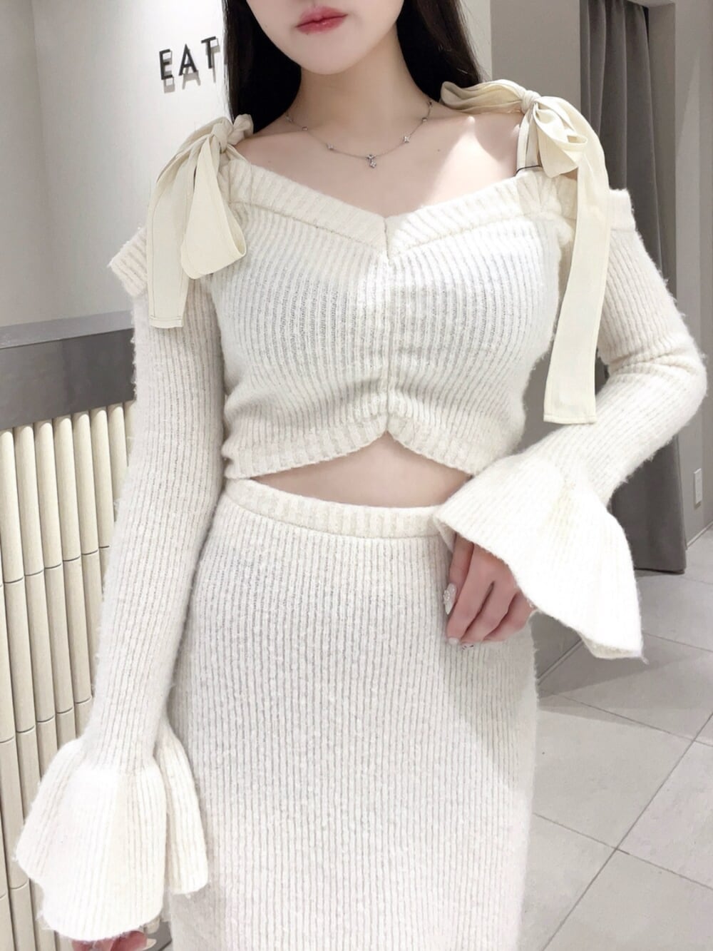 ホワイト系のワンピース、ブラック系のブーツを着用したレディースの冬コーディネートの5枚目の写真