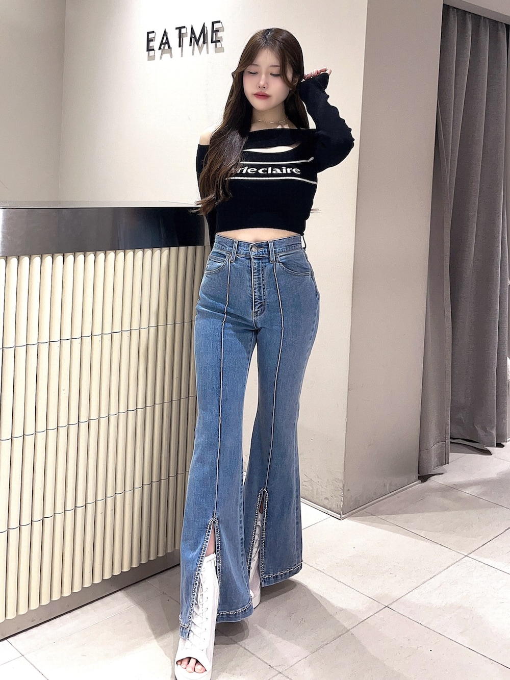 ホワイト系のブーツ、ブルー系のデニムパンツ、ブラック系のニット/セーターを着用したレディースの春コーディネートの2枚目の写真