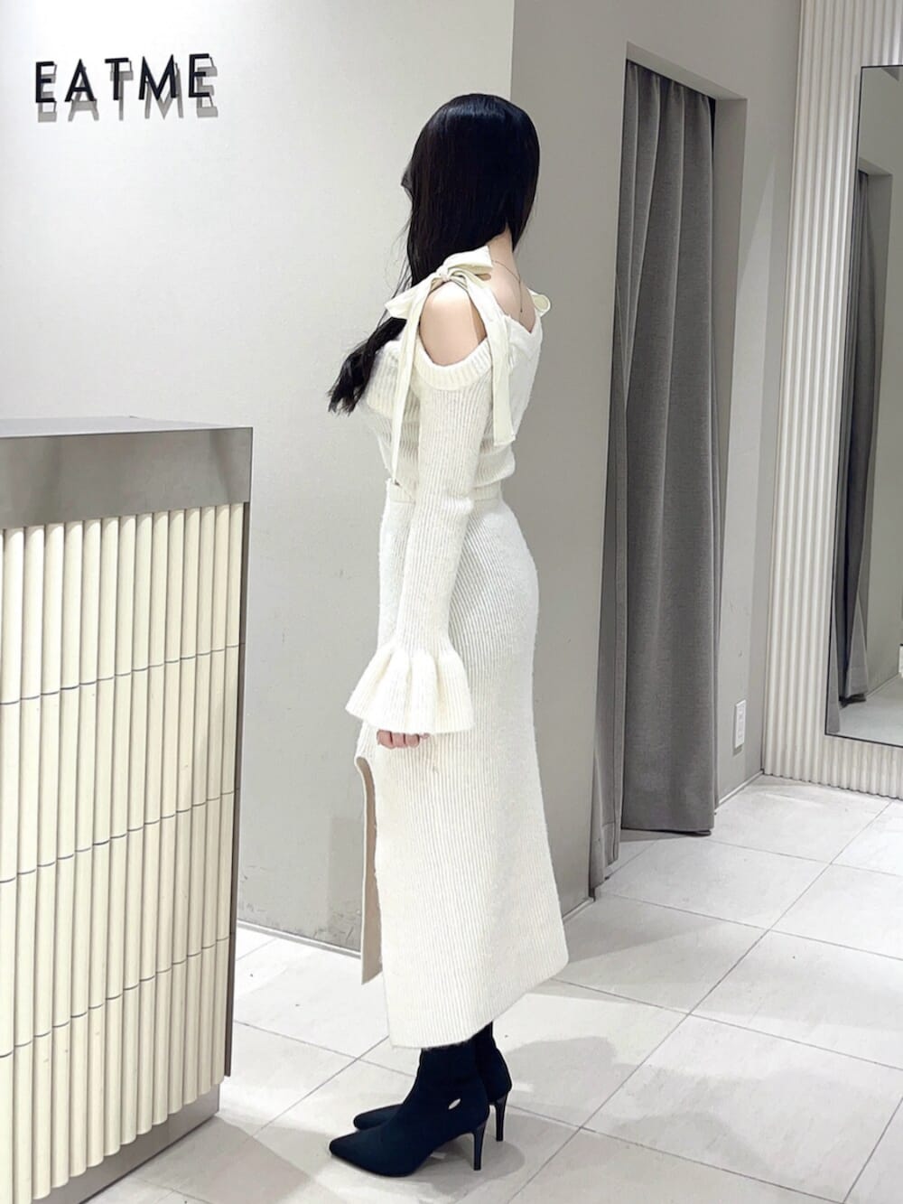 ホワイト系のワンピース、ブラック系のブーツを着用したレディースの冬コーディネートの3枚目の写真