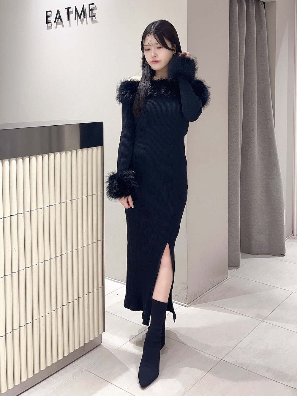 ブラック系のワンピース、ブラック系のブーツを着用したレディースの秋コーディネートの2枚目の写真