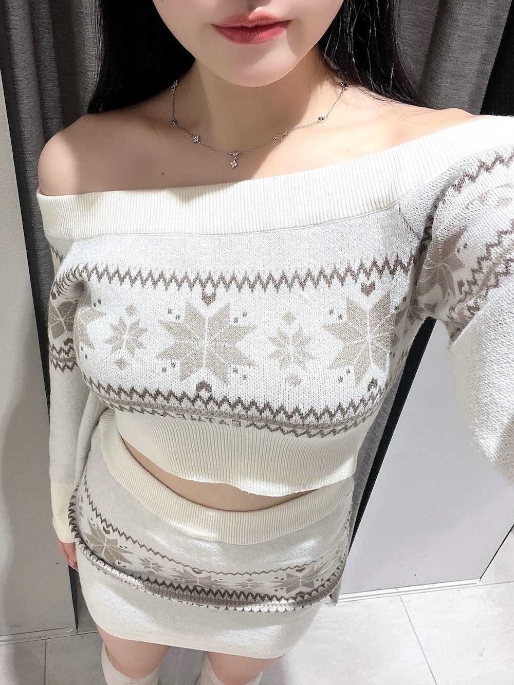 ホワイト系のニット/セーター、ホワイト系のスカート、ホワイト系のブーツを着用したレディースの秋コーディネートの5枚目の写真