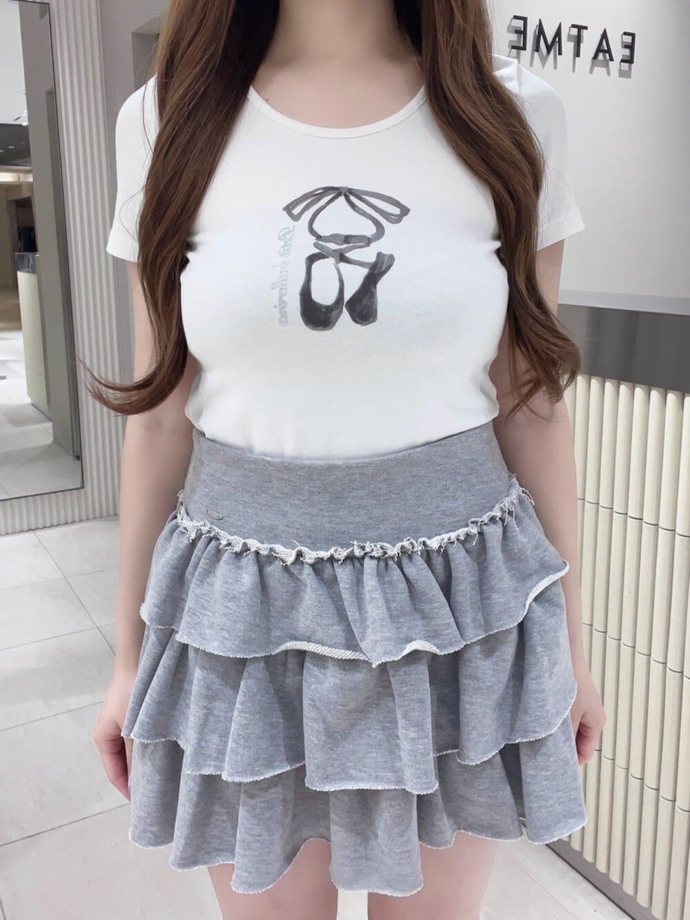 グレー系のスカート、ホワイト系のTシャツ/カットソー、ホワイト系のショルダーバッグを着用したレディースの夏コーディネートの4枚目の写真