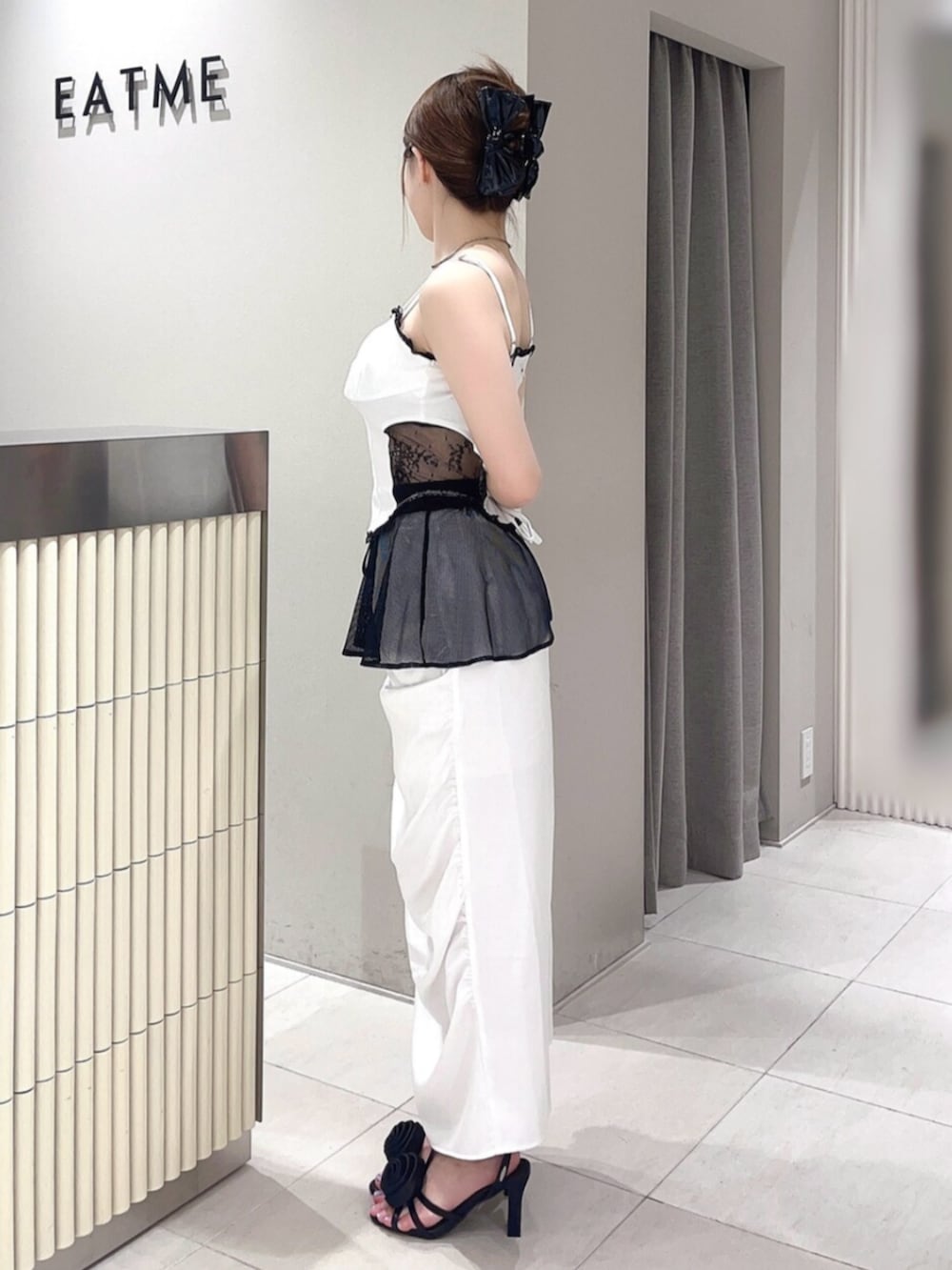 ホワイト系のキャミソール、ホワイト系のスカート、ブラック系のサンダルを着用したレディースの夏コーディネートの2枚目の写真