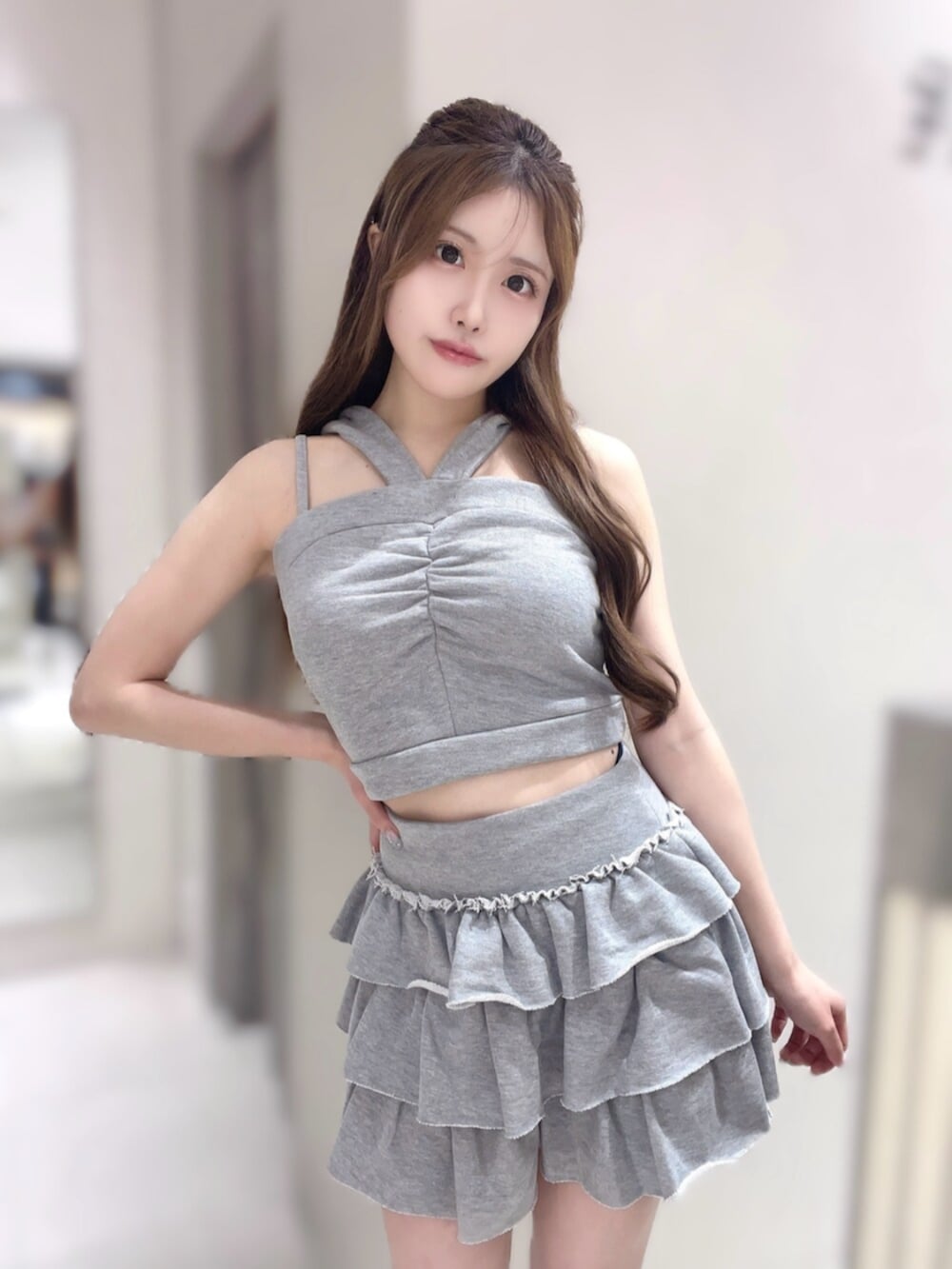 グレー系のキャミソール、グレー系のスカート、ホワイト系のスニーカーを着用したレディースの夏コーディネートの4枚目の写真