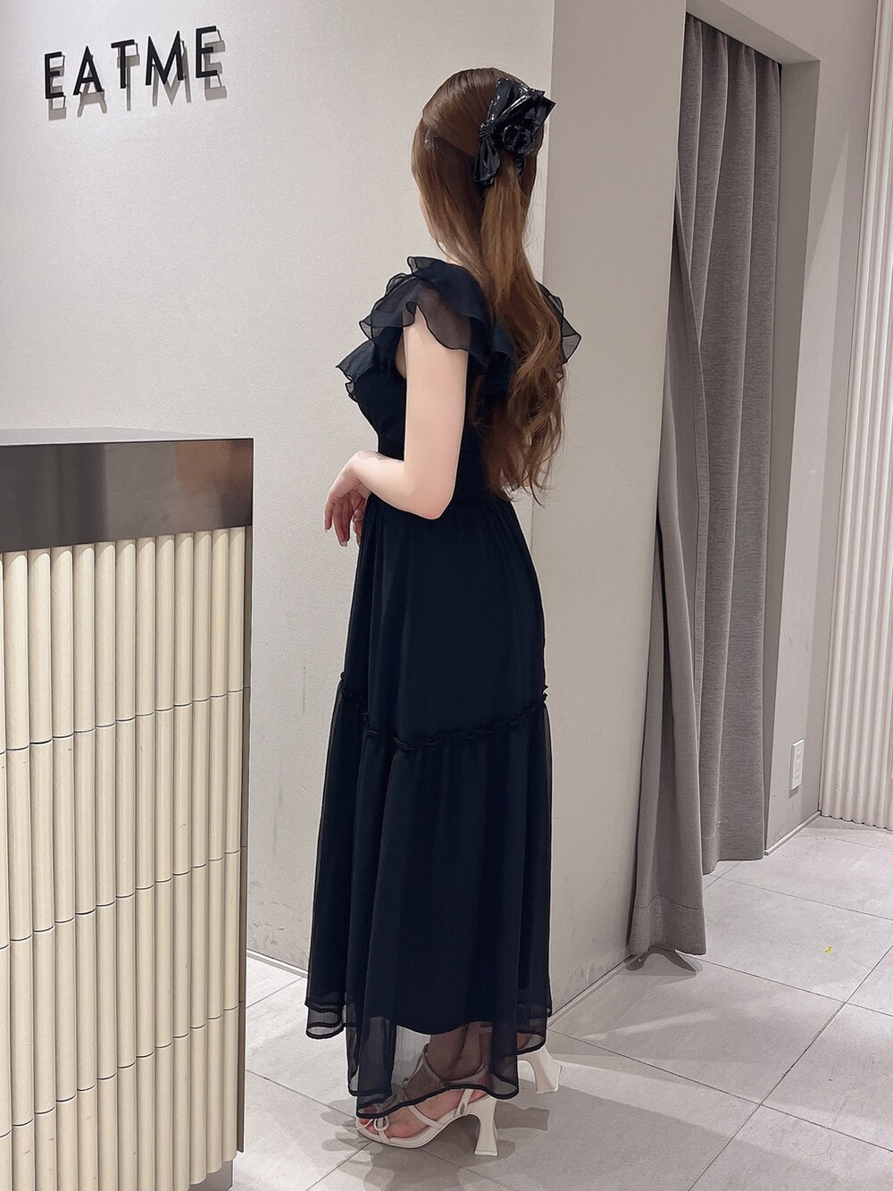 ブラック系のワンピース、ホワイト系のサンダルを着用したレディースの夏コーディネートの2枚目の写真