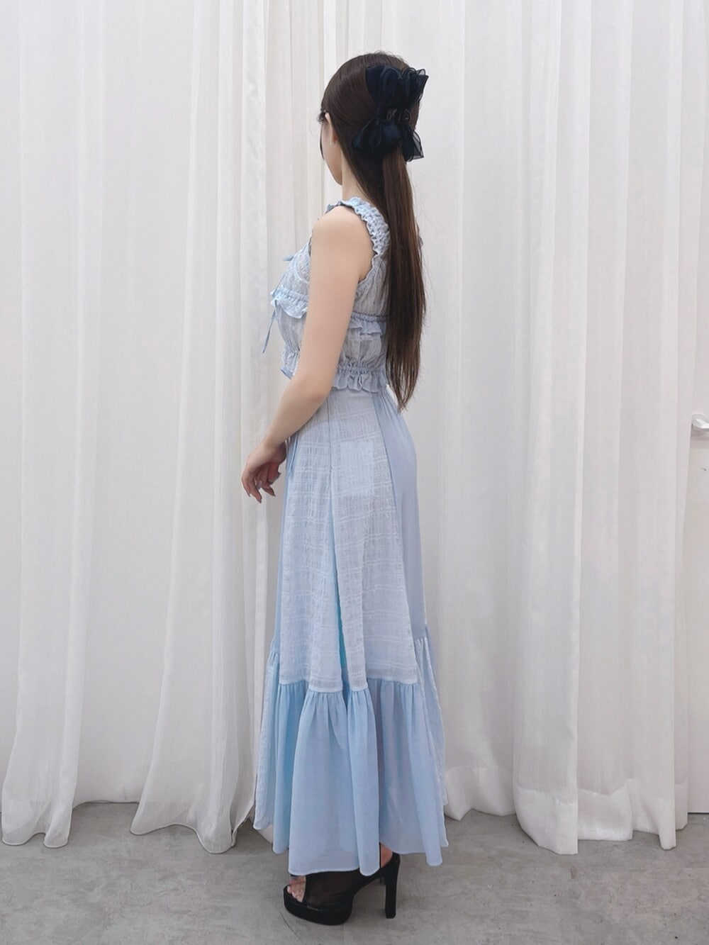 ブラック系のサンダル、ブルー系のキャミソール、ブルー系のスカートを着用したレディースの夏コーディネートの2枚目の写真