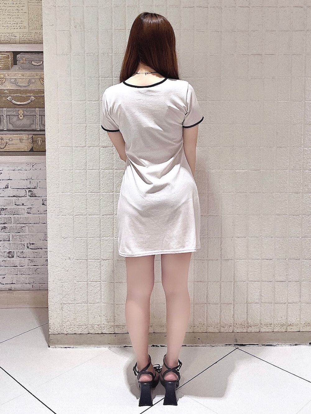 ホワイト系のワンピース、ブラック系のサンダル、ブラック系のチョーカーを着用したレディースの夏コーディネートの4枚目の写真