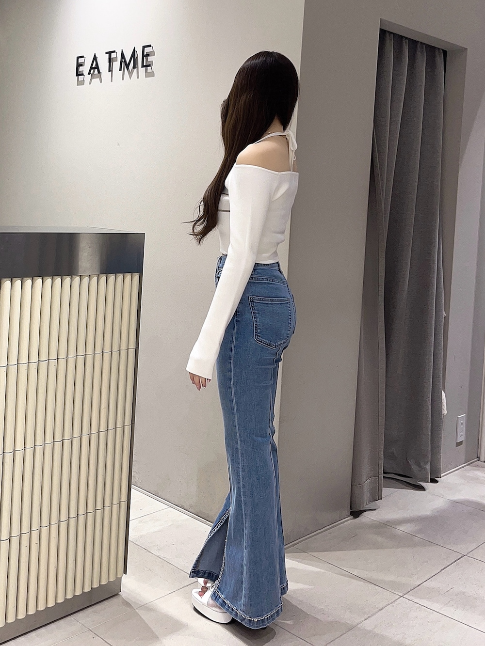 ホワイト系のニット/セーター、ブルー系のデニムパンツ、ホワイト系のブーツを着用したレディースの春コーディネートの2枚目の写真