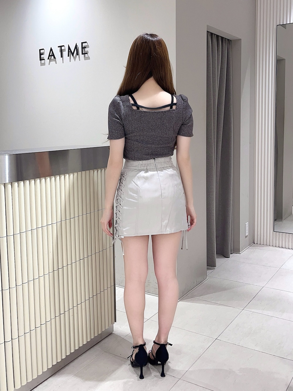 グレー系のTシャツ/カットソー、グレー系のスカート、ブラック系のサンダルを着用したレディースの夏コーディネートの3枚目の写真