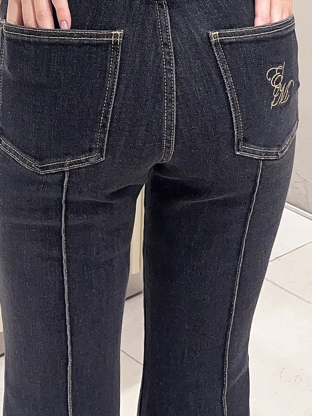 ブルー系のニット/セーター、ブラック系のデニムパンツ、ブラック系のブーツを着用したレディースの春コーディネートの5枚目の写真