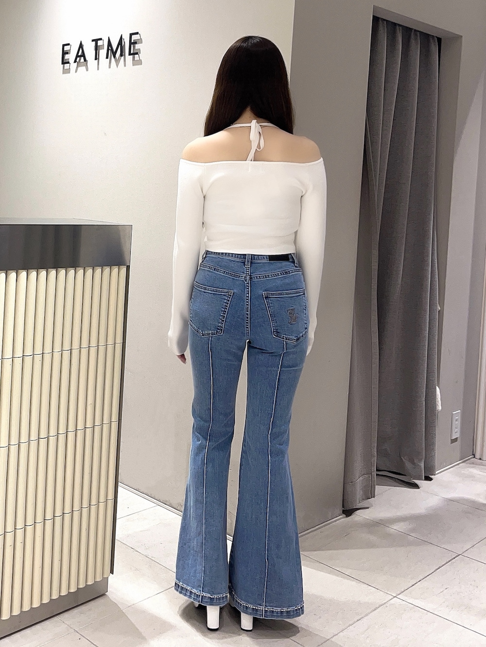 ホワイト系のニット/セーター、ブルー系のデニムパンツ、ホワイト系のブーツを着用したレディースの春コーディネートの3枚目の写真