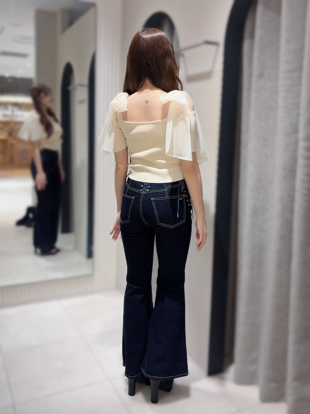 ホワイト系のTシャツ/カットソー、ブルー系のデニムパンツ、ブラック系のサンダルを着用したレディースの春コーディネートの3枚目の写真