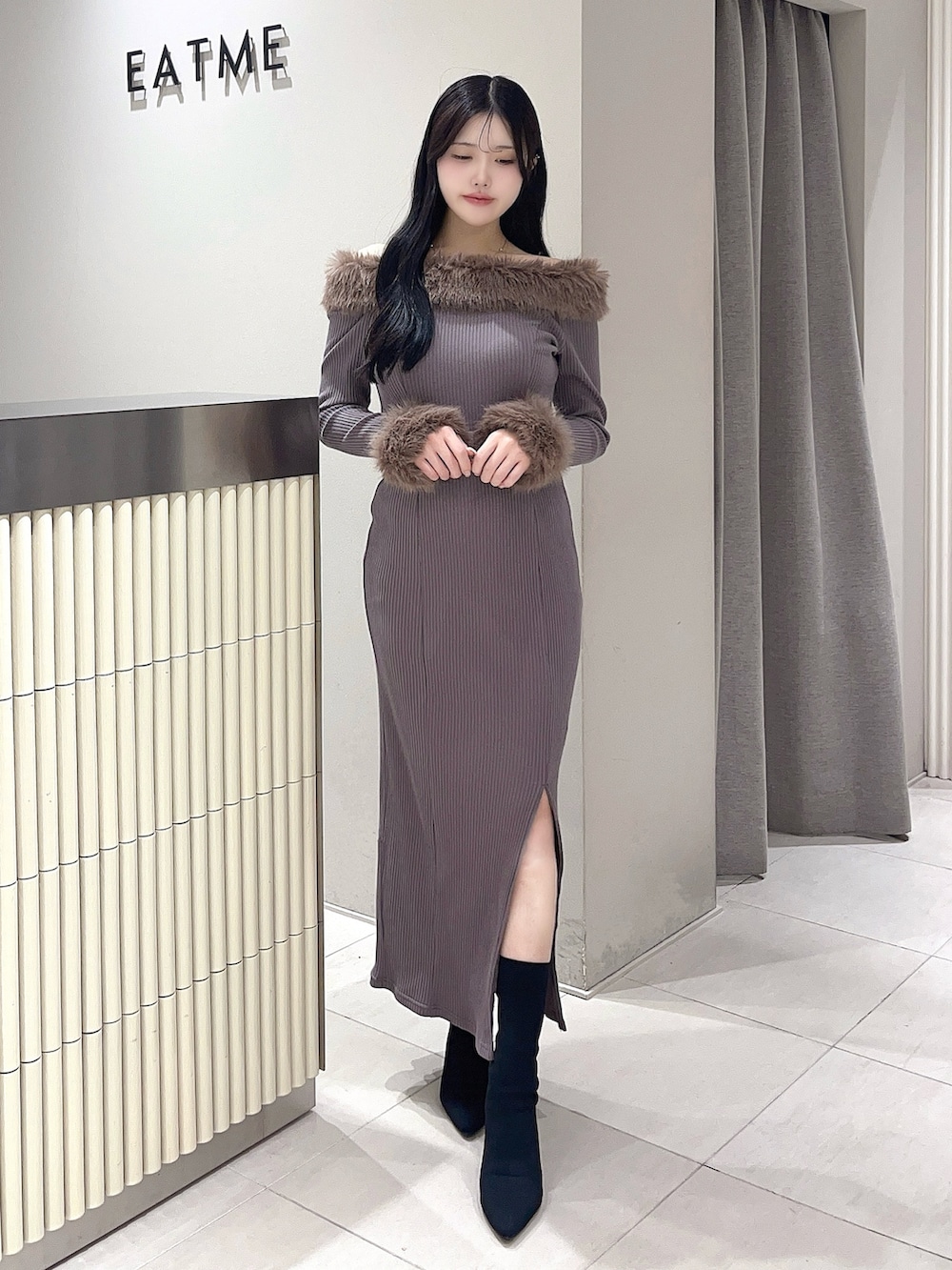 ブラウン系のワンピース、ブラック系のブーツを着用したレディースの秋コーディネートの2枚目の写真