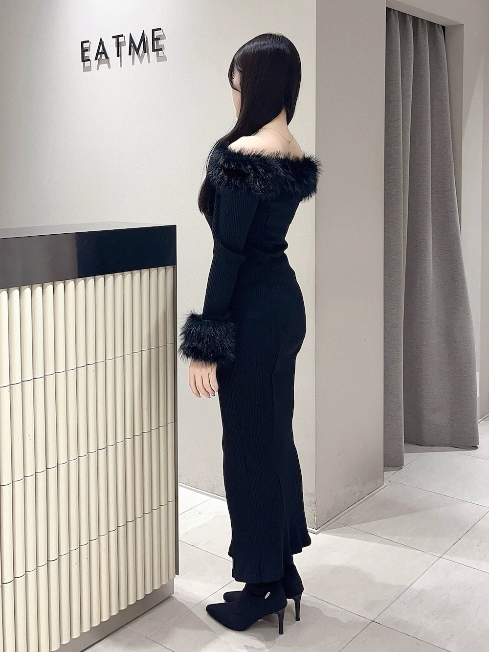 ブラック系のワンピース、ブラック系のブーツを着用したレディースの秋コーディネートの3枚目の写真