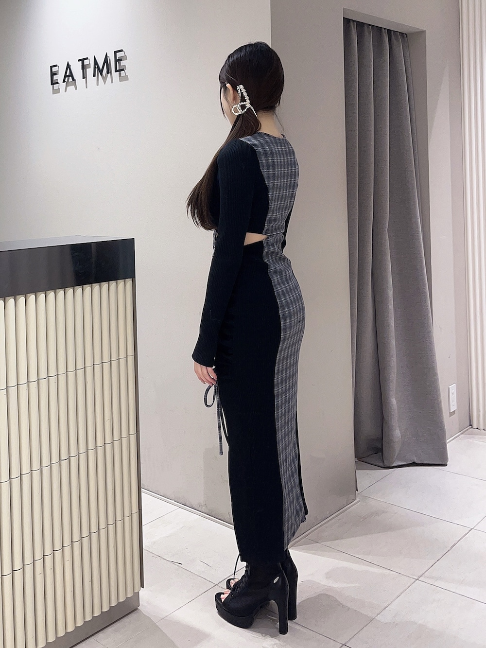 ブラック系のブーツ、その他のワンピース、ゴールド系のバレッタ/ヘアクリップを着用したレディースの冬コーディネートの2枚目の写真