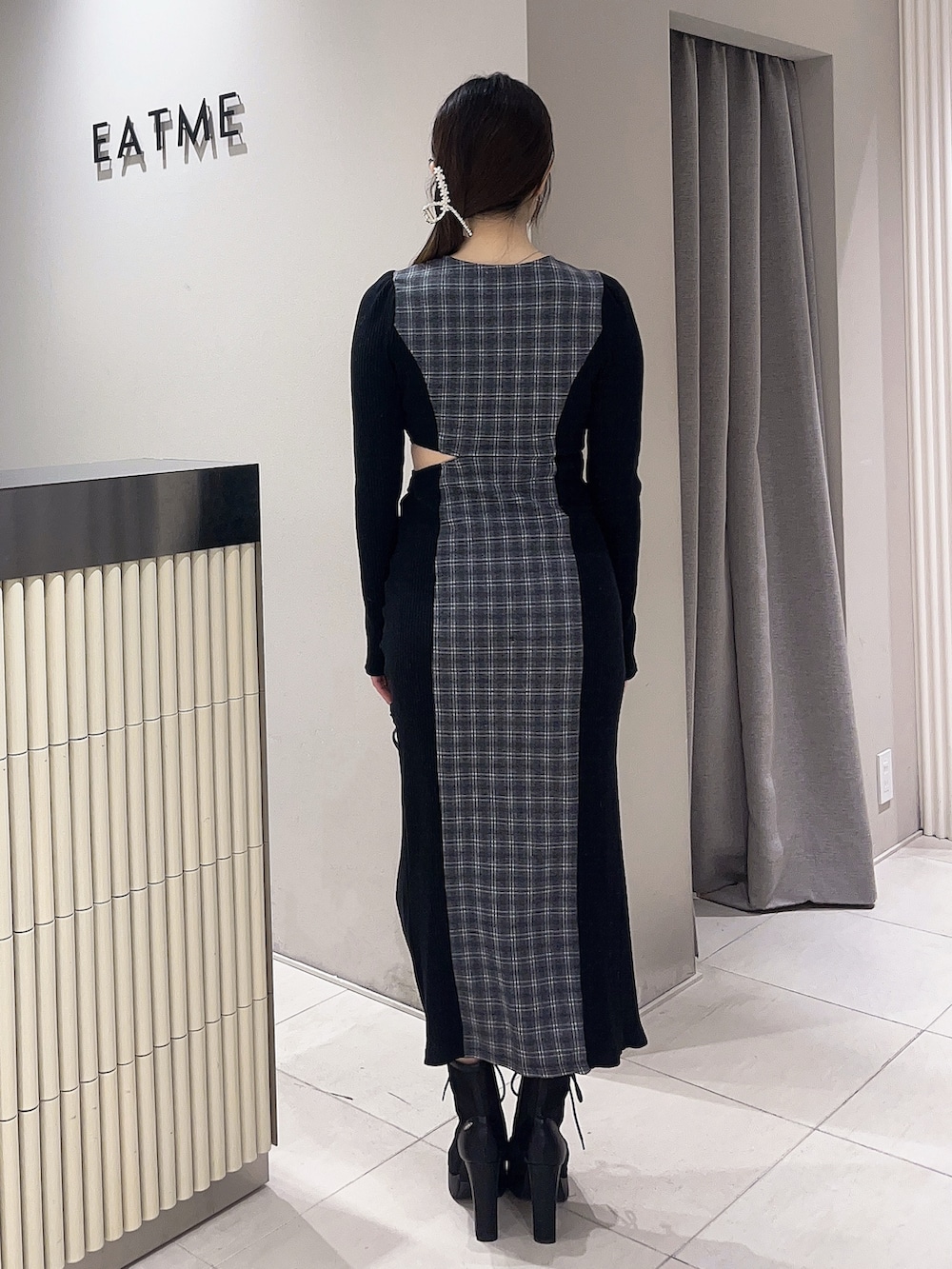 ブラック系のブーツ、その他のワンピース、ゴールド系のバレッタ/ヘアクリップを着用したレディースの冬コーディネートの3枚目の写真