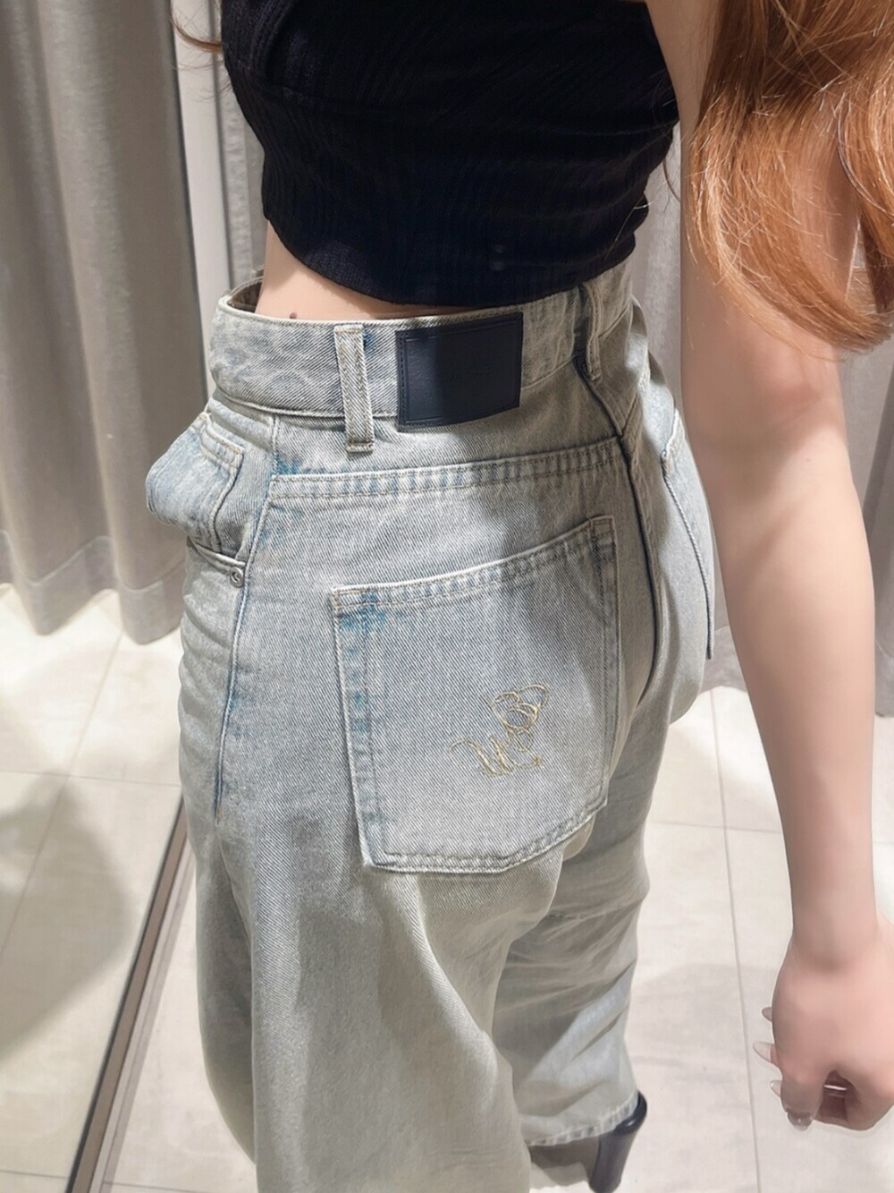 ブラック系のタンクトップ、ブルー系のデニムパンツ、ブラック系のサンダルを着用したレディースの夏コーディネートの5枚目の写真