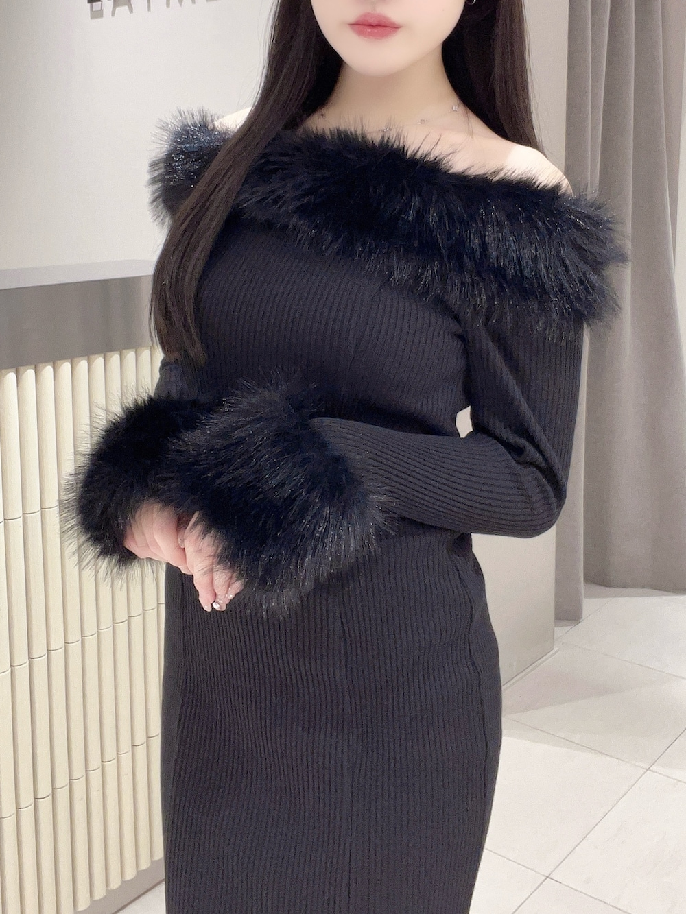 ブラック系のワンピース、ブラック系のブーツを着用したレディースの秋コーディネートの5枚目の写真