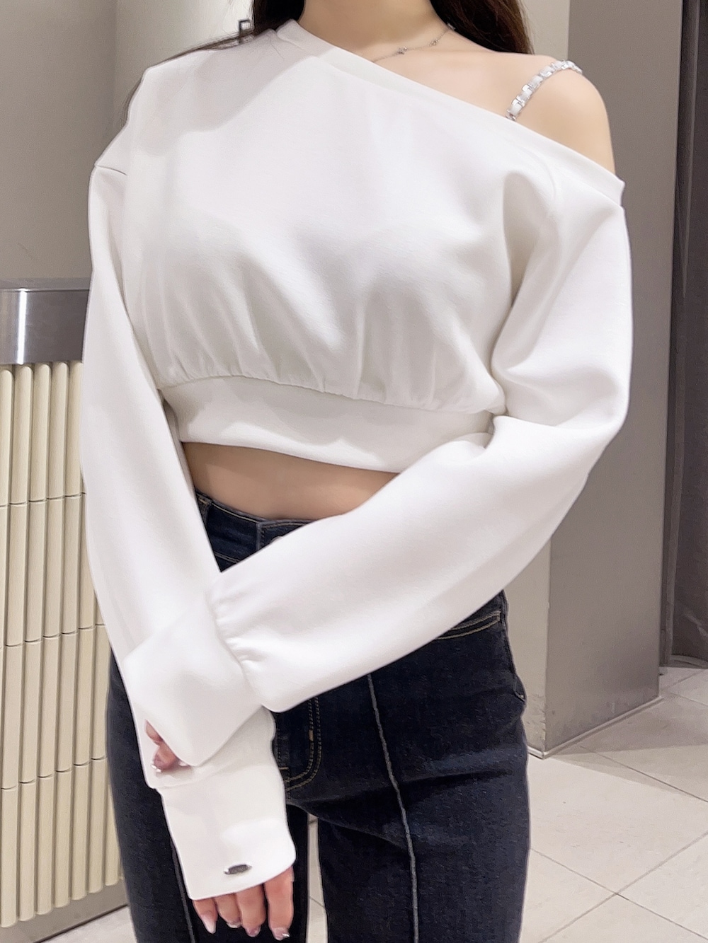 ホワイト系のスウェット、ブラック系のデニムパンツ、ブラック系のブーツを着用したレディースの春コーディネートの4枚目の写真