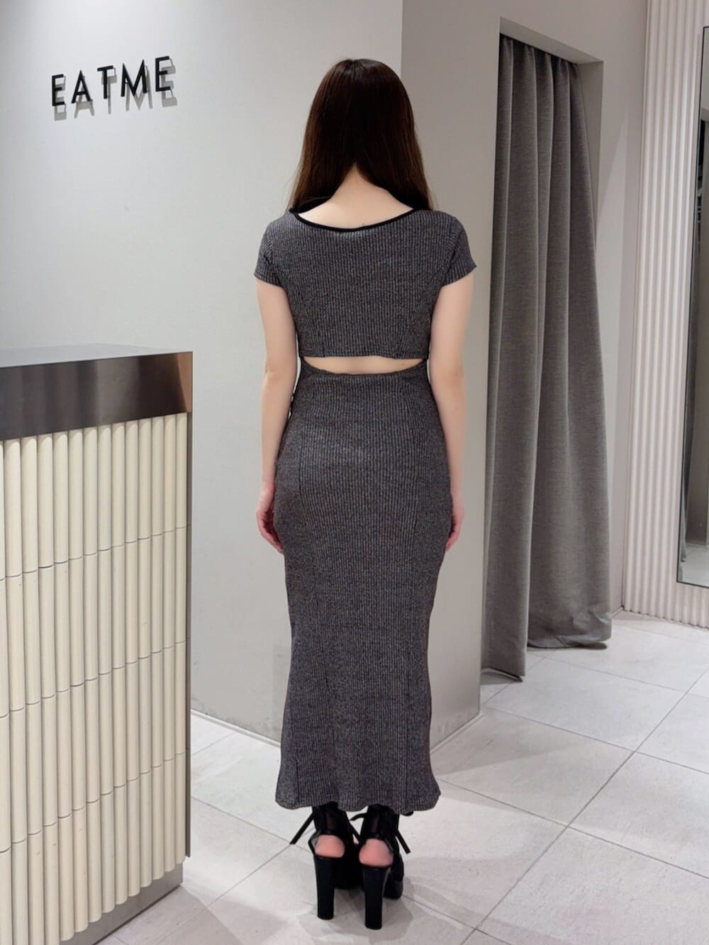 グレー系のワンピース、ブラック系のサンダルを着用したレディースの春コーディネートの3枚目の写真