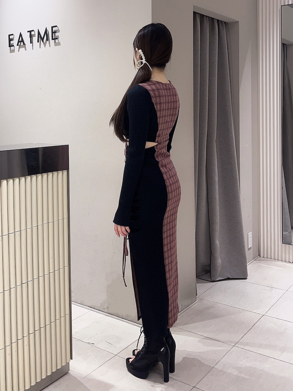 その他のワンピース、ブラック系のブーツ、ゴールド系のバレッタ/ヘアクリップを着用したレディースの冬コーディネートの2枚目の写真