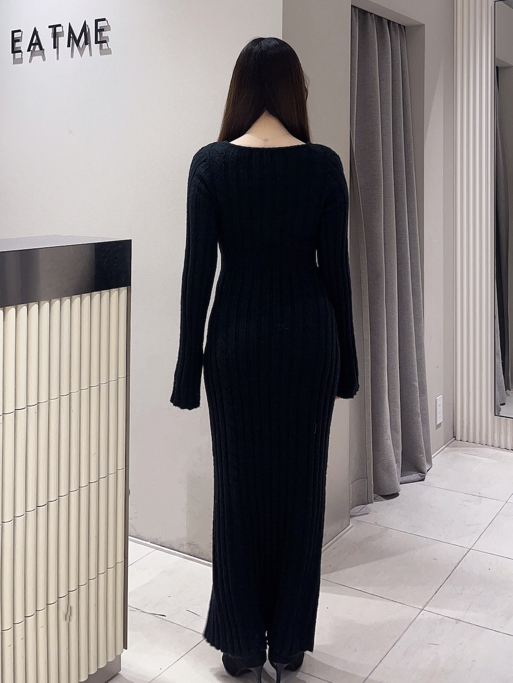 ブラック系のワンピース、ブラック系のブーツを着用したレディースの冬コーディネートの4枚目の写真