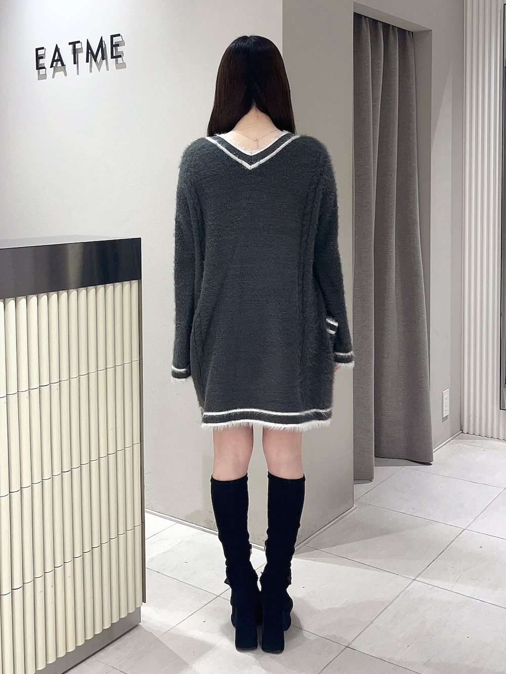 グレー系のワンピース、ブラック系のブーツを着用したレディースの冬コーディネートの3枚目の写真