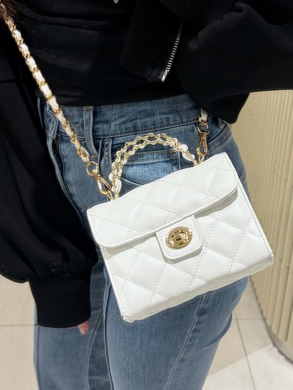 ブラック系のTシャツ/カットソー、ブラック系のパーカー、ホワイト系のハンドバッグを着用したレディースの春コーディネートの5枚目の写真