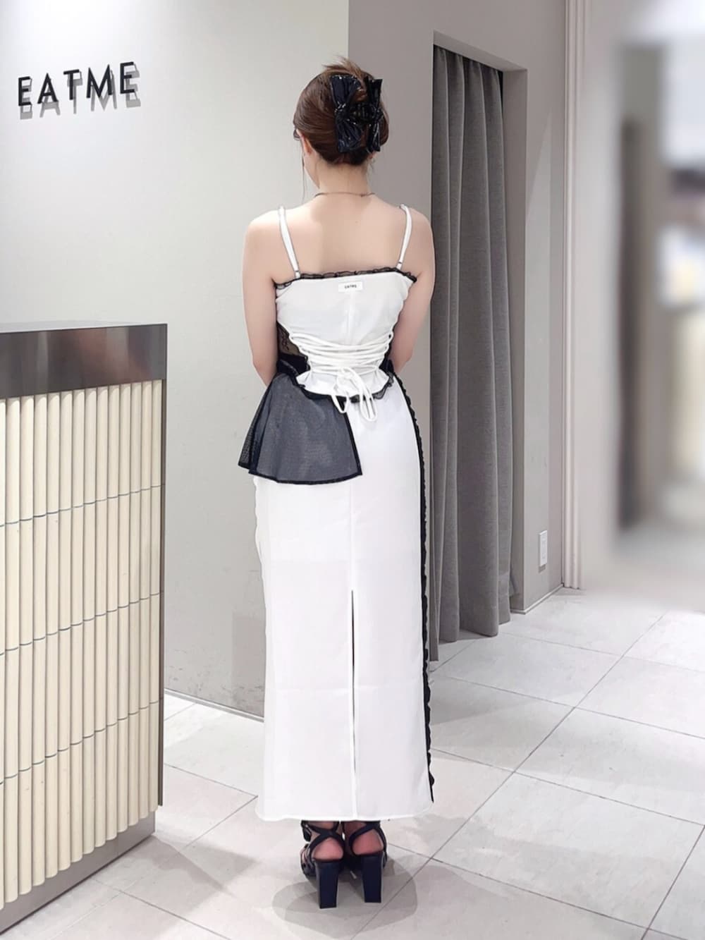 ホワイト系のキャミソール、ホワイト系のスカート、ブラック系のサンダルを着用したレディースの夏コーディネートの3枚目の写真