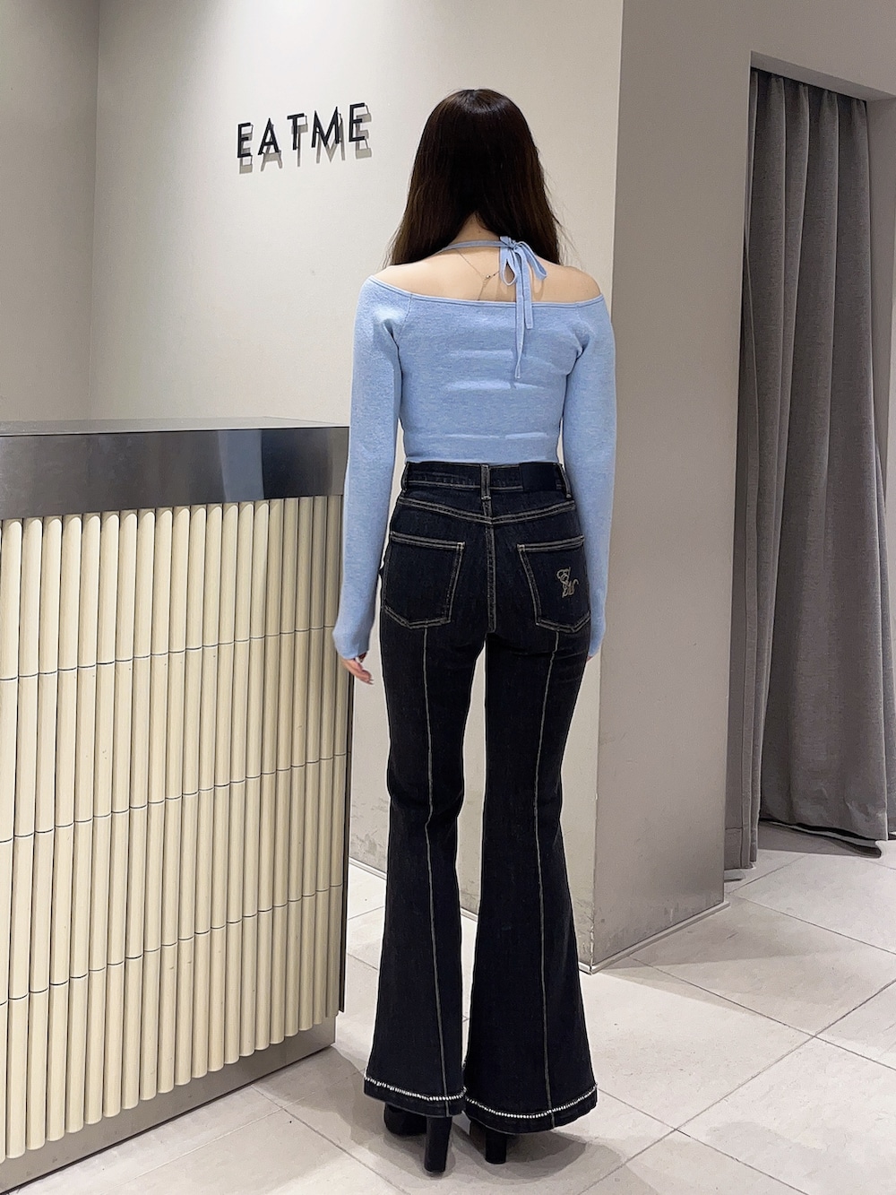 ブルー系のニット/セーター、ブラック系のデニムパンツ、ブラック系のブーツを着用したレディースの春コーディネートの3枚目の写真