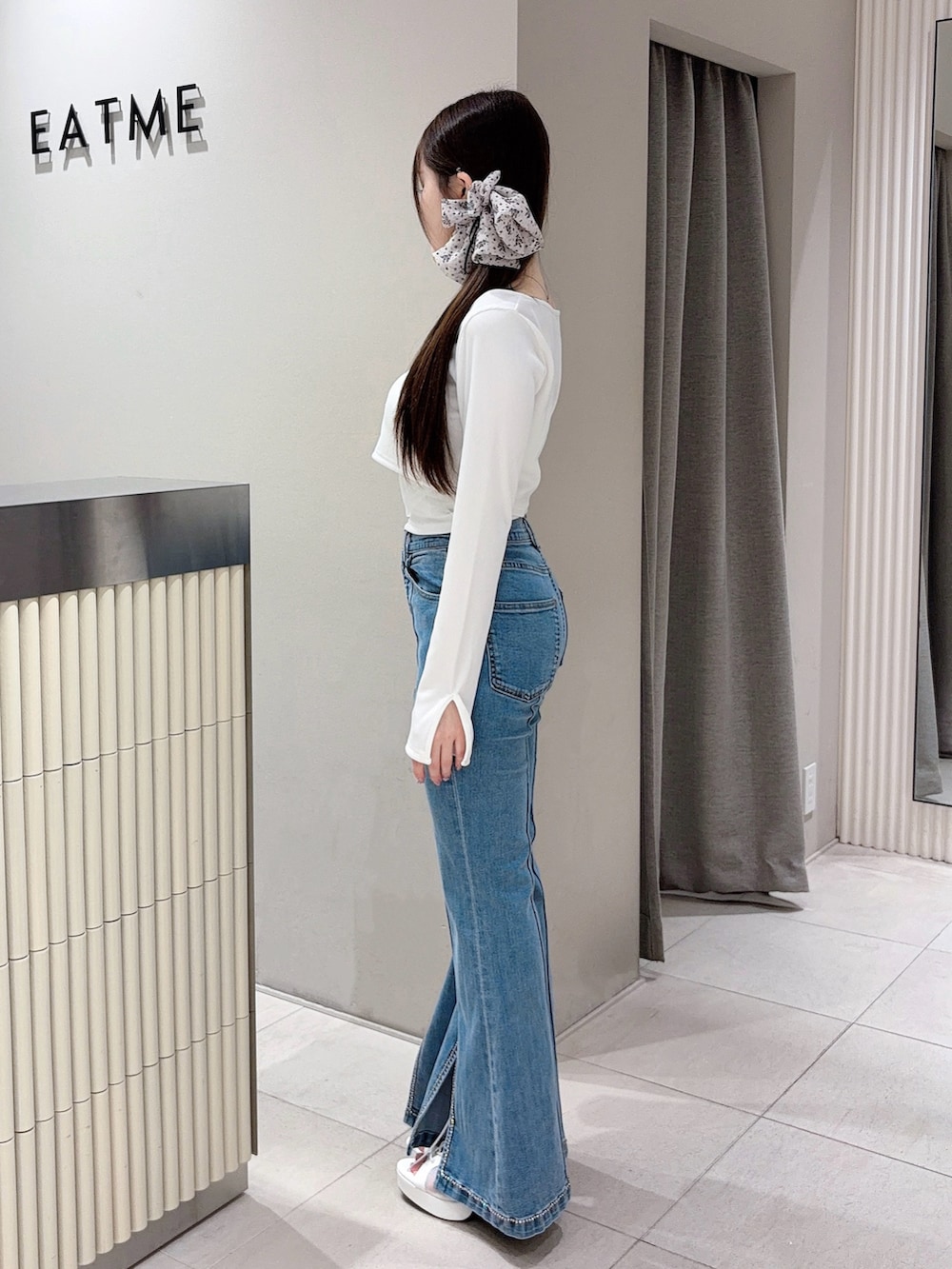 ホワイト系のTシャツ/カットソー、ブルー系のデニムパンツ、ホワイト系のブーツを着用したレディースの春コーディネートの2枚目の写真