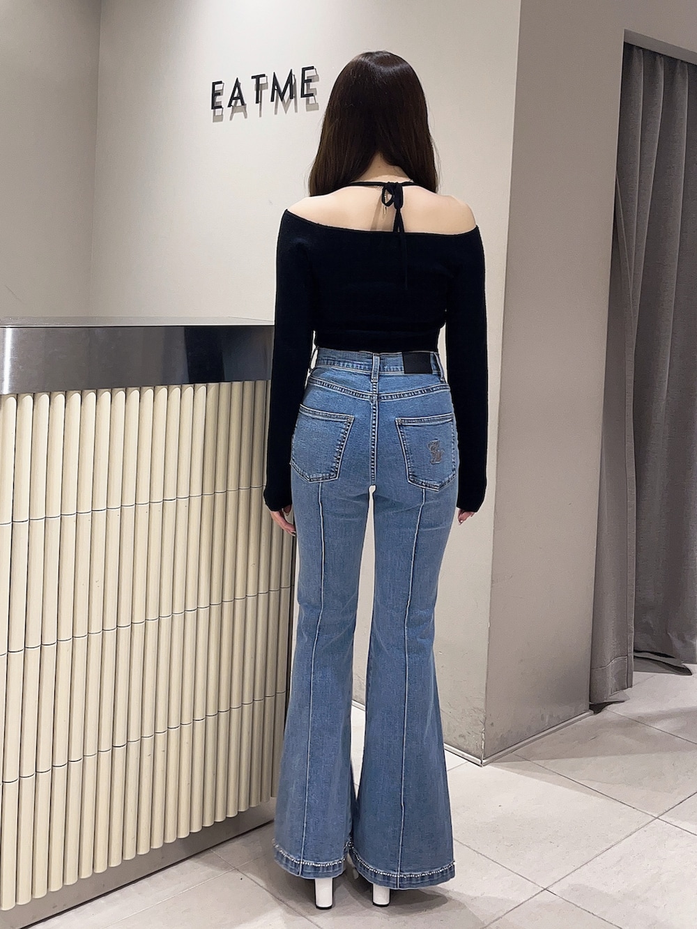 ホワイト系のブーツ、ブルー系のデニムパンツ、ブラック系のニット/セーターを着用したレディースの春コーディネートの4枚目の写真