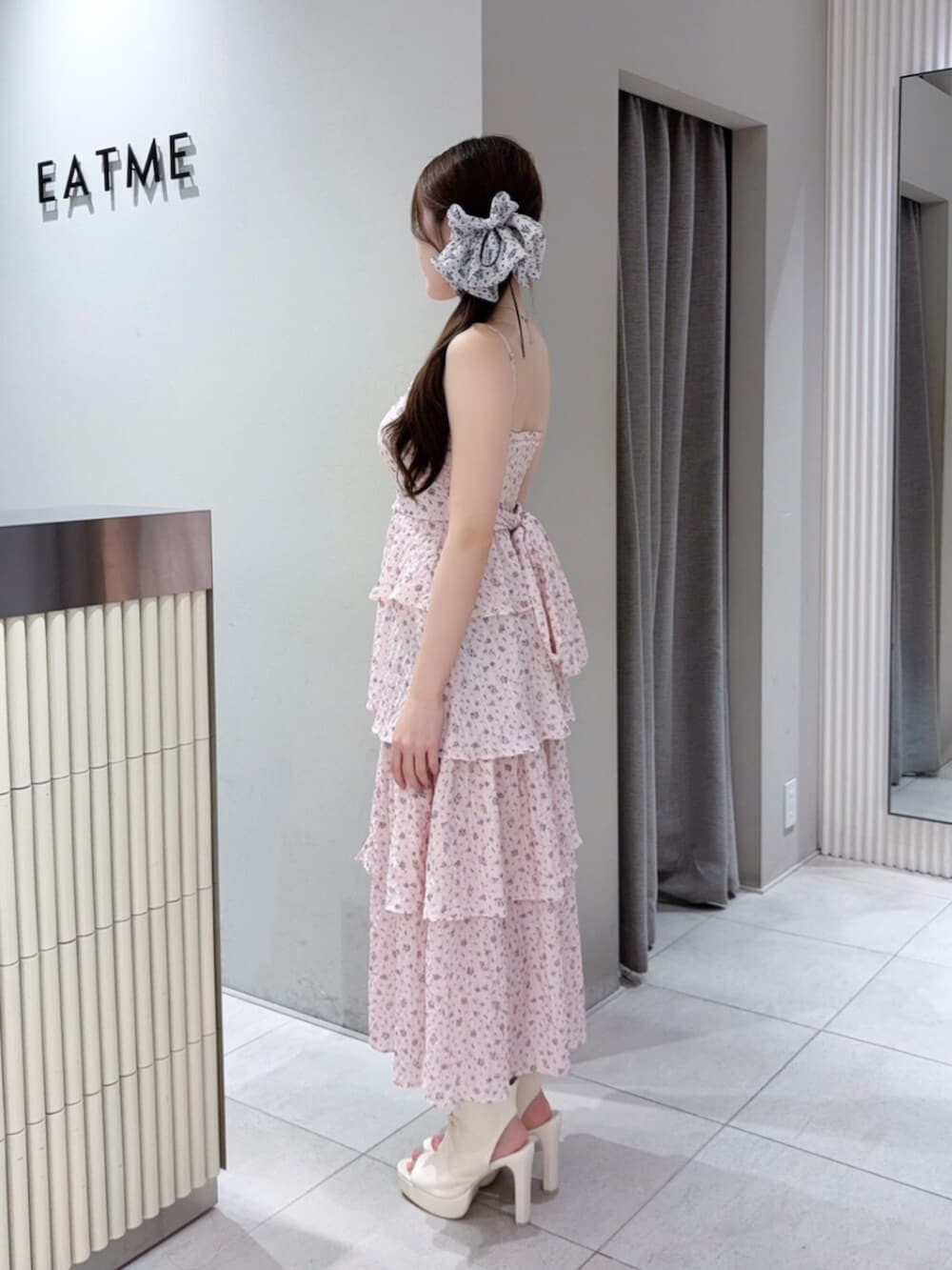 ピンク系のワンピース、ホワイト系のハンドバッグ、ホワイト系のサンダルを着用したレディースの夏コーディネートの3枚目の写真