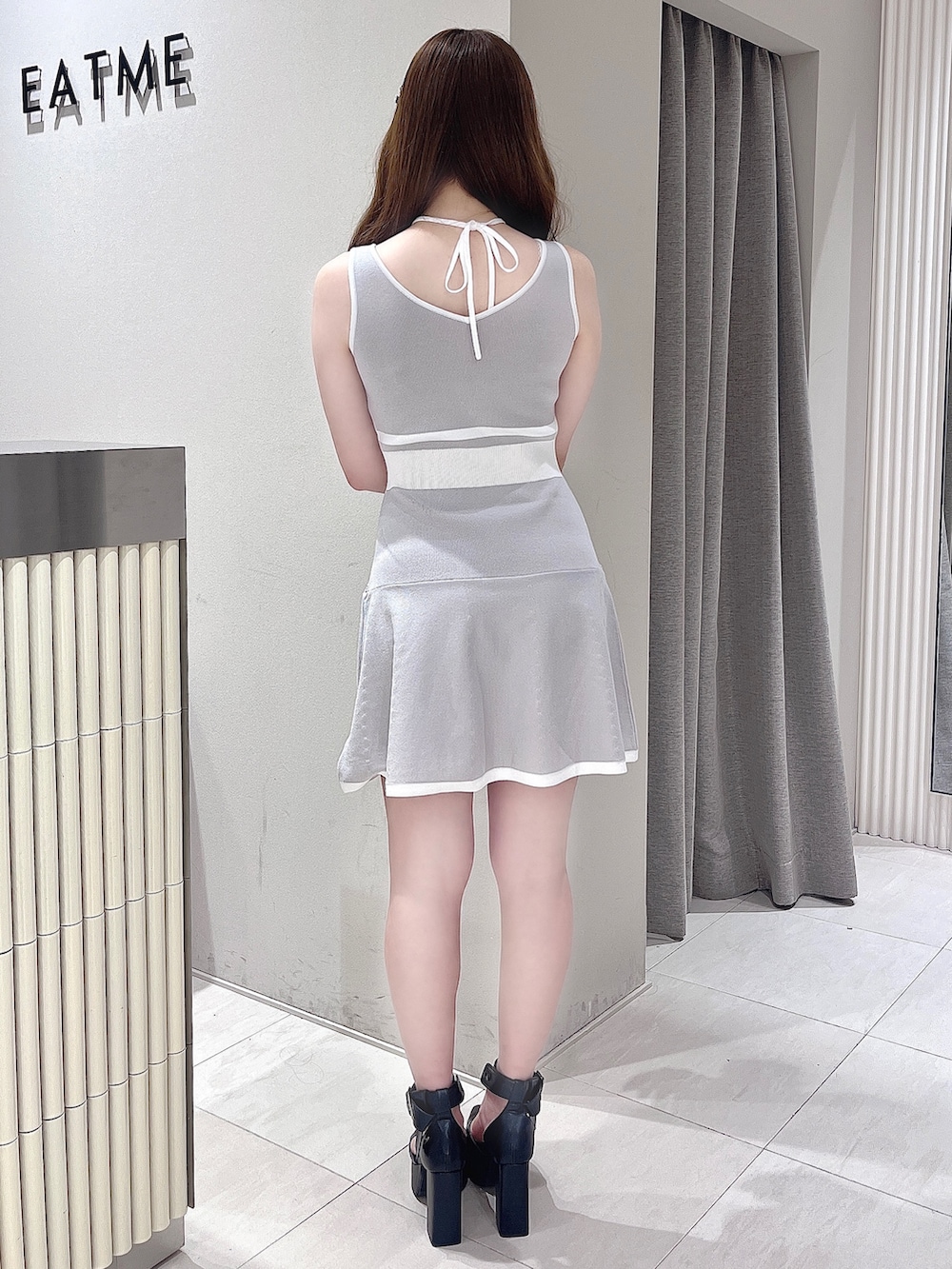 グレー系のワンピース、ブラック系のパンプス、ブラック系のヘアピンを着用したレディースの夏コーディネートの4枚目の写真