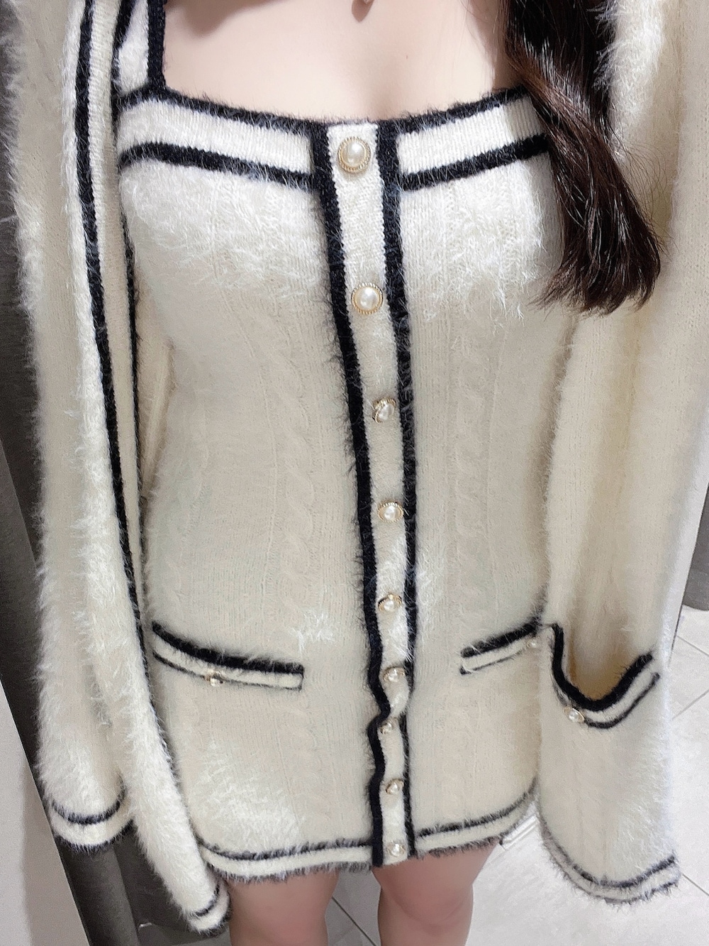 ホワイト系のワンピース、ブラック系のブーツを着用したレディースの冬コーディネートの5枚目の写真