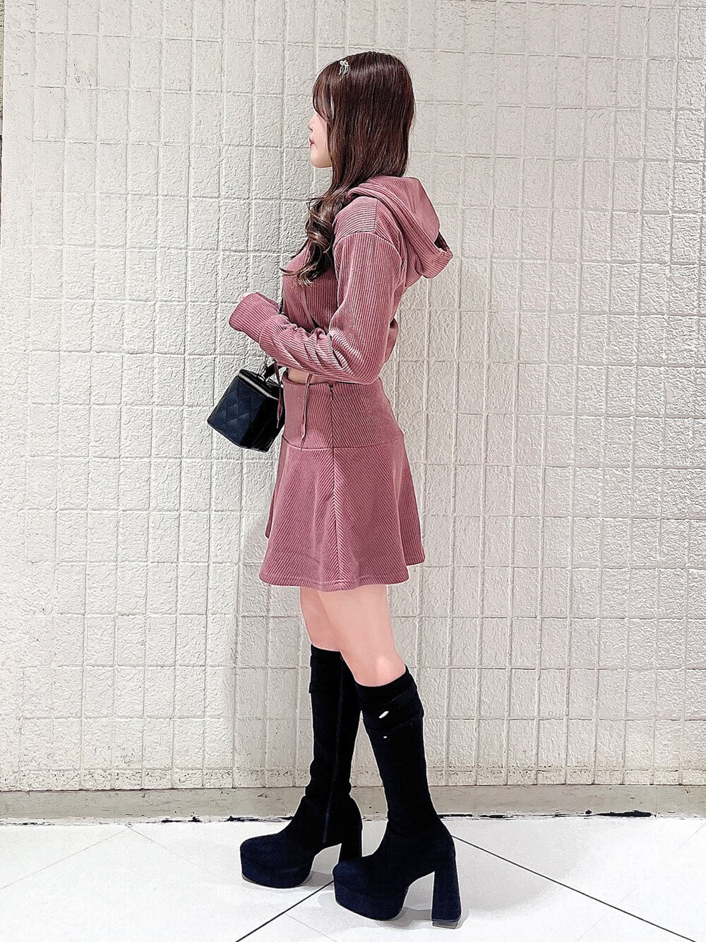 ピンク系のパーカー、ピンク系のスカート、ブラック系のハンドバッグを着用したレディースの秋コーディネートの3枚目の写真