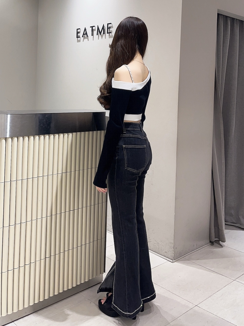 ブラック系のTシャツ/カットソー、ブラック系のデニムパンツ、ブラック系のブーツを着用したレディースの春コーディネートの2枚目の写真